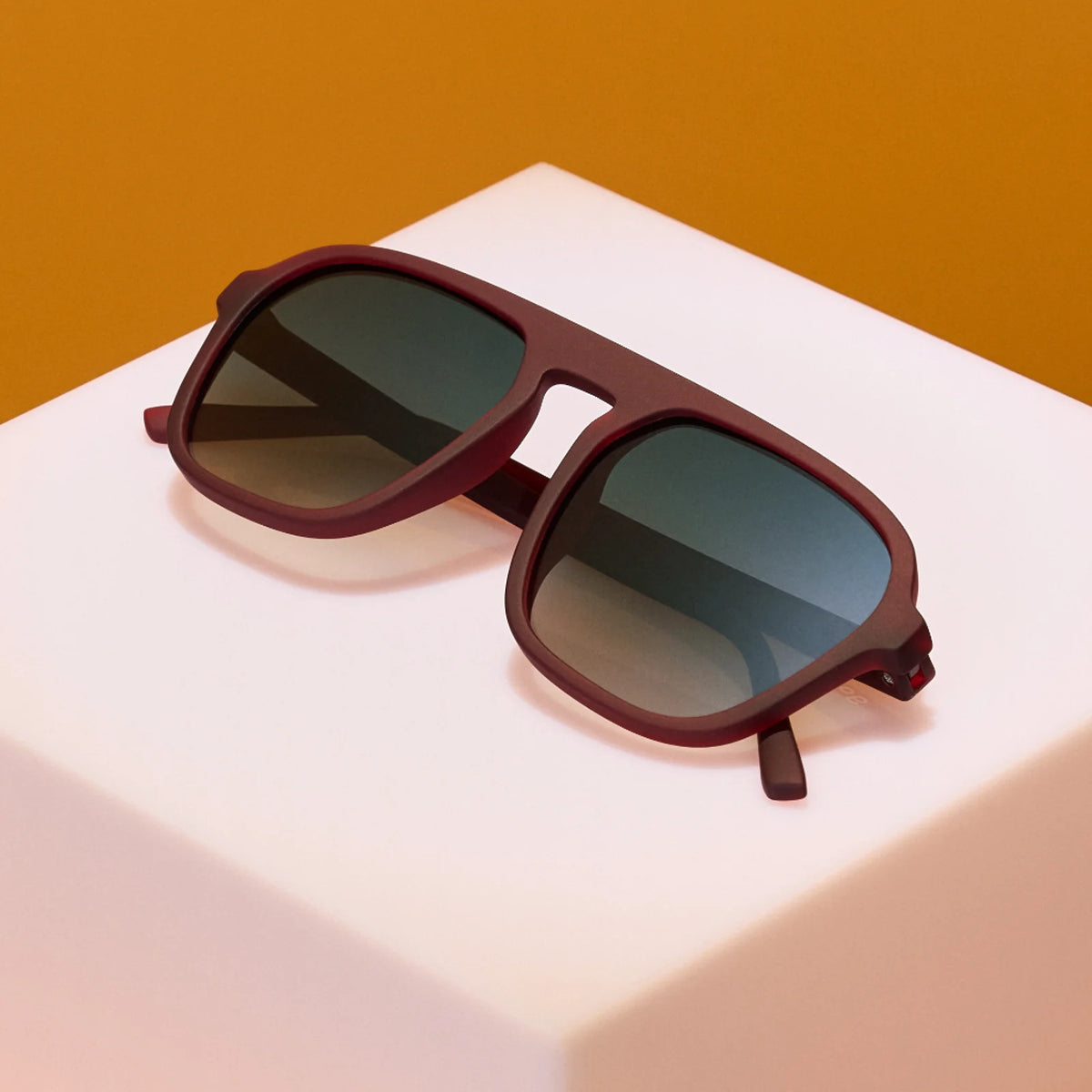 Product close up of brown aviator style sunglasses with green gradient lenses.