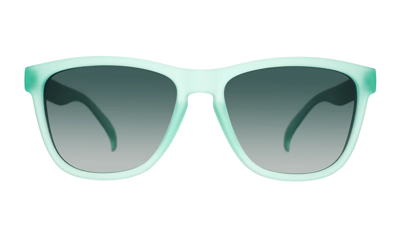 Product close up of mint coloured square-framed sunglasses, with dark green gradient lenses.