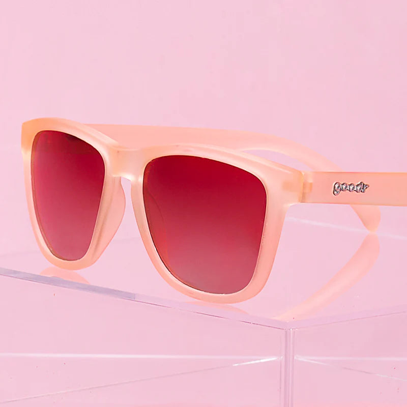Product close up of pink square-shaped sunglasses with pink gradient lenses.