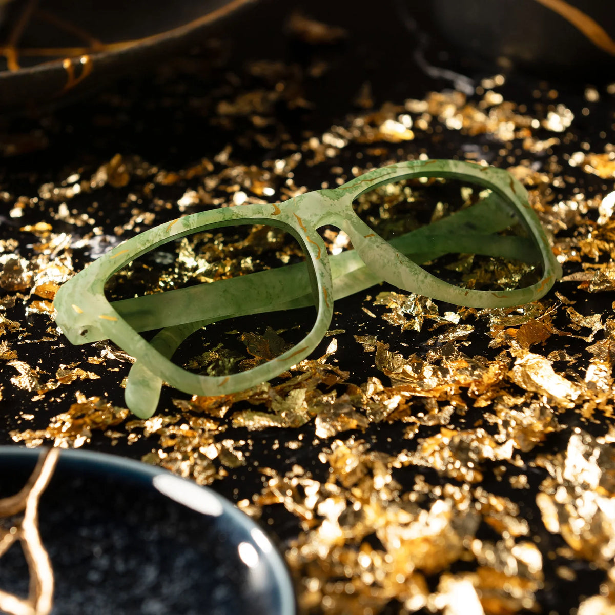 Marbled green square shaped sunglasses with a prominent golden line pattern, reminiscent of Kintsugi. 