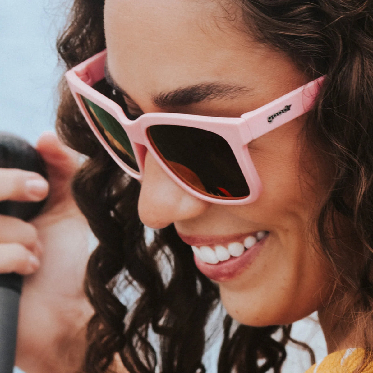 Fit and style showcase of pink sunglasses with mirrored reflective lenses. Water repellent and capable of floating.