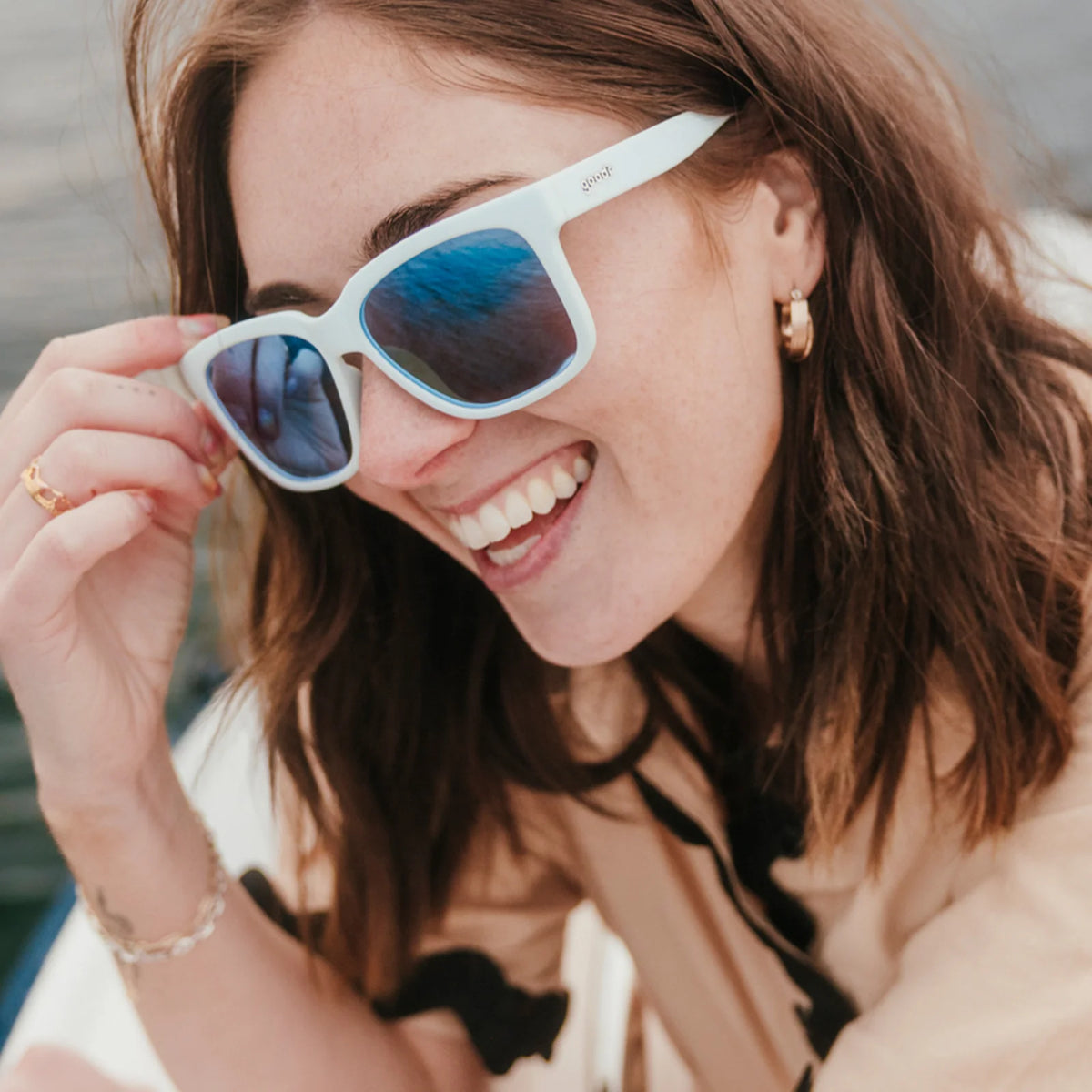 Fit and style showcase of light blue sunglasses with mirrored reflective lenses. Water repellent and capable of floating.